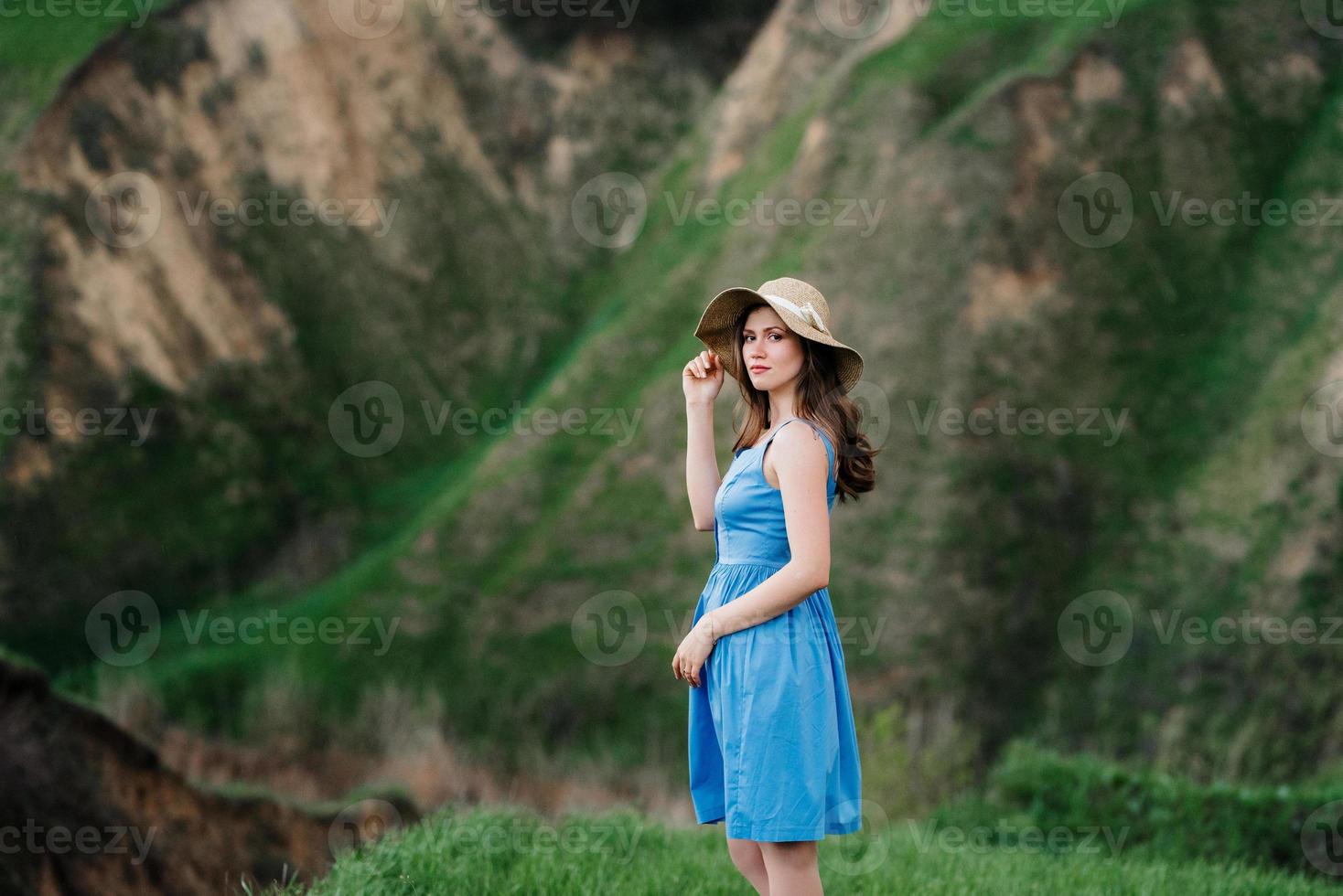 young girl in a straw hat with large brim on mountain slopes photo