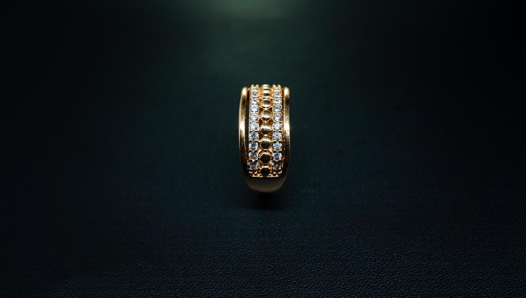 foto del anillo de oro de la mujer sobre un fondo negro
