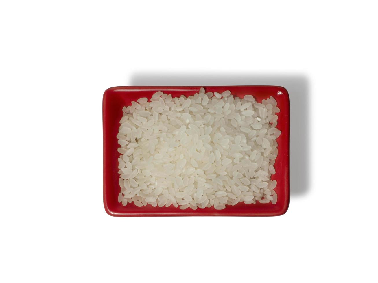 Rice in a red rectangular saucer isolated on white background. The view from above photo