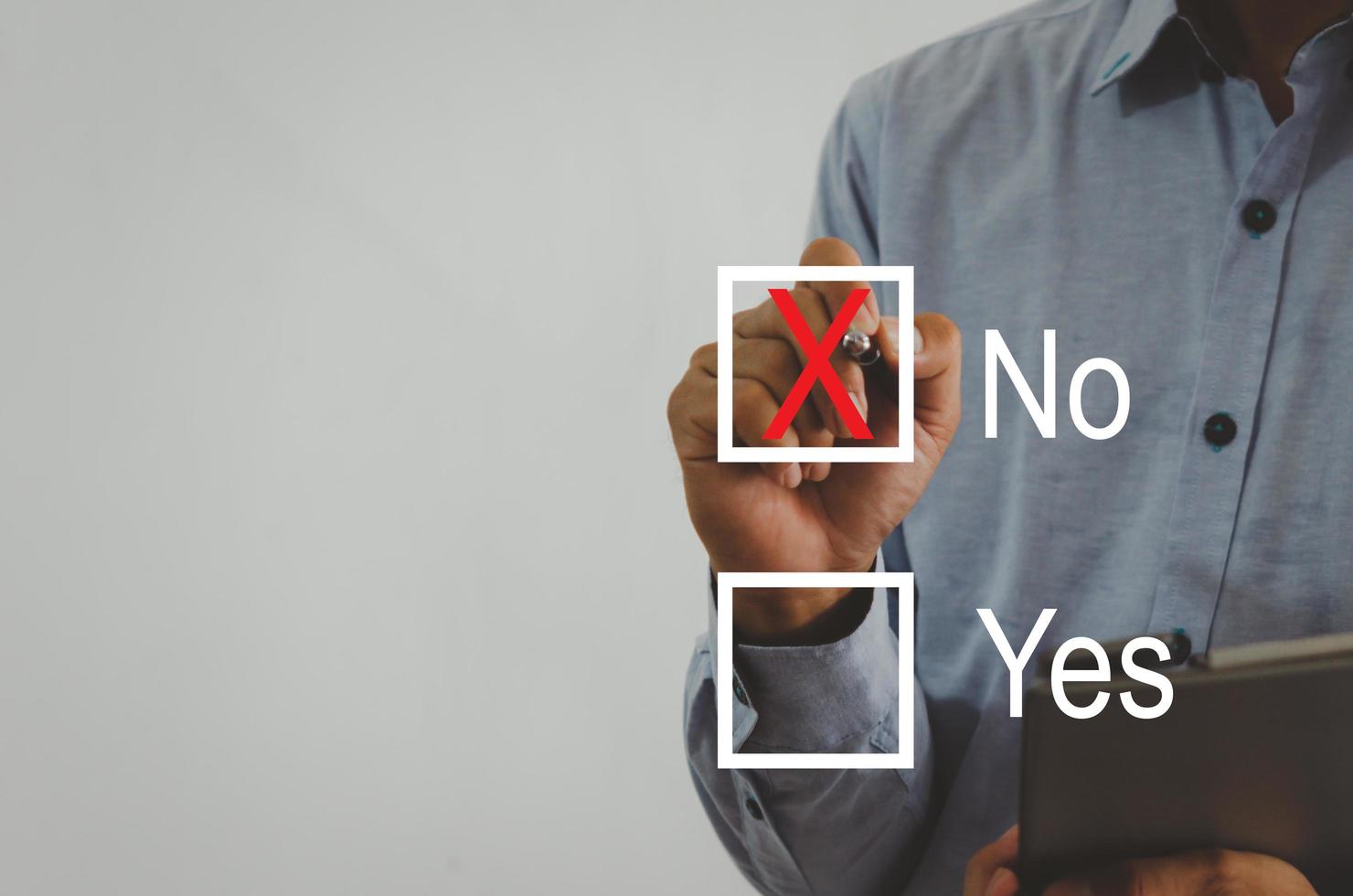 businessman holding a pen with a red cross on the square a virtual screen photo