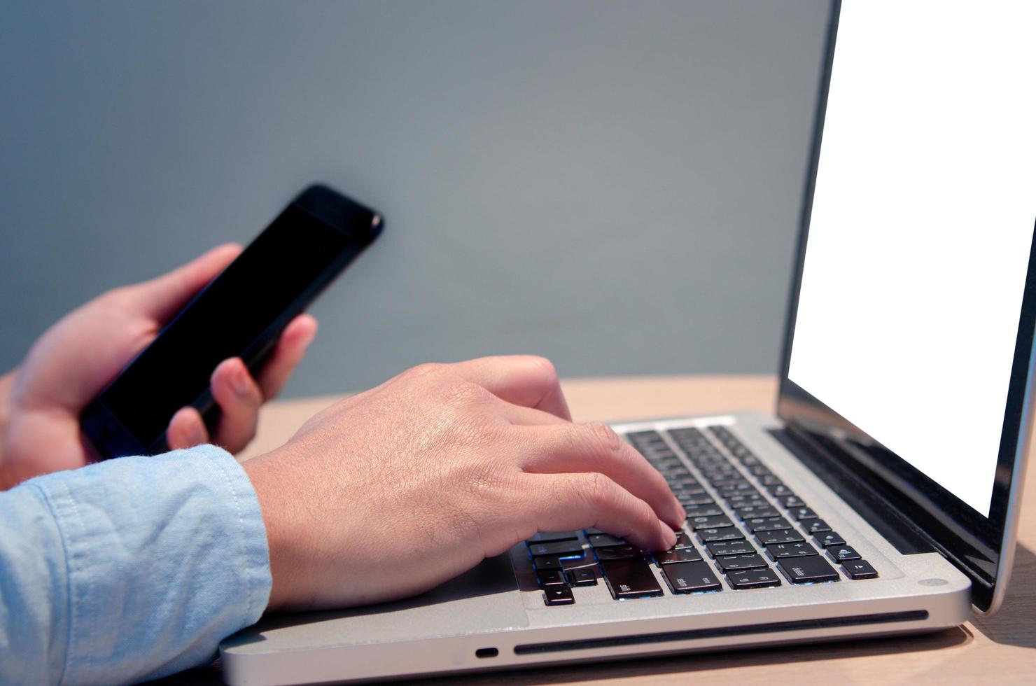 businessman hand typing computer at desk with blank screen mock up photo