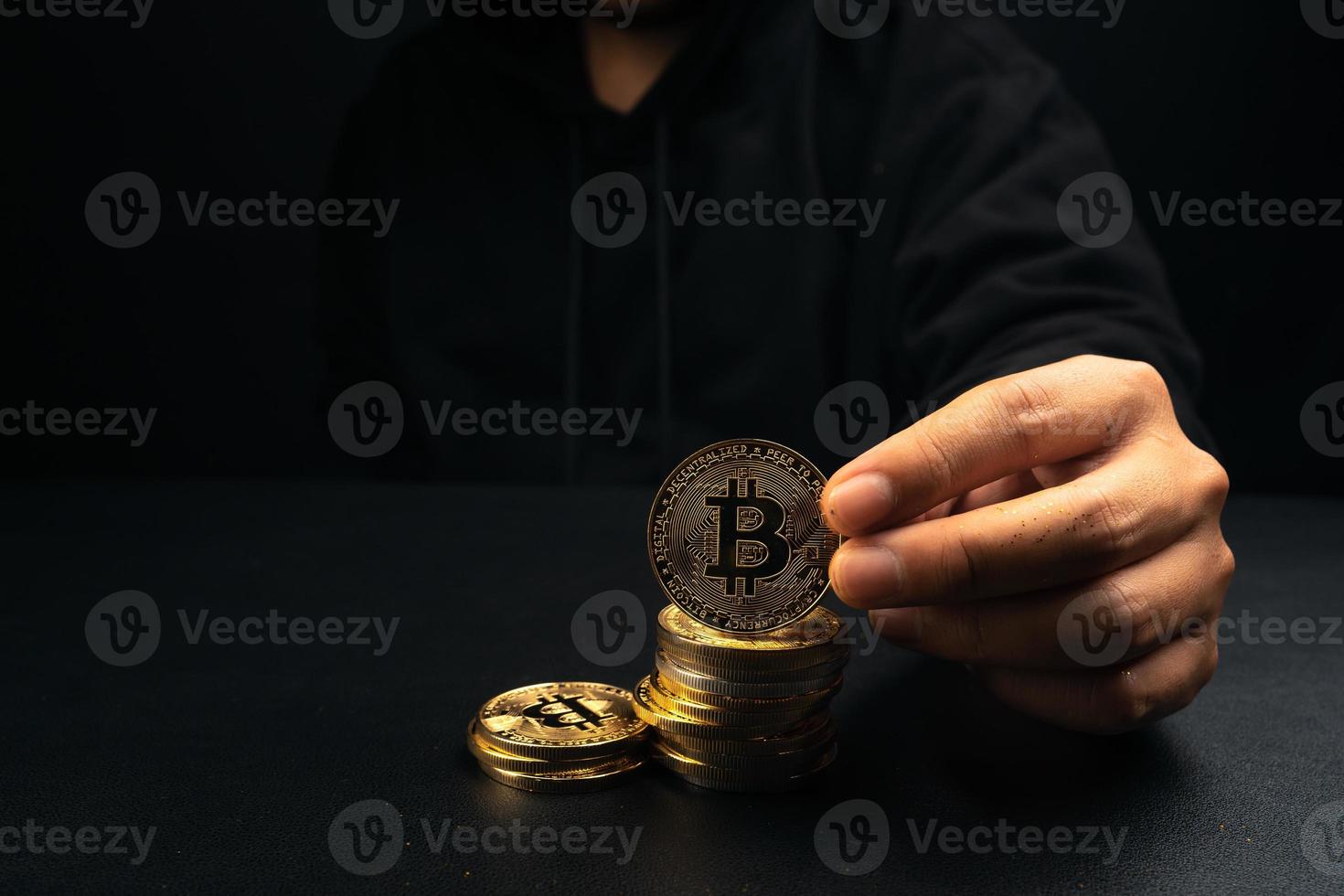 un bitcoin dorado en la mano de un hombre misterioso. foto