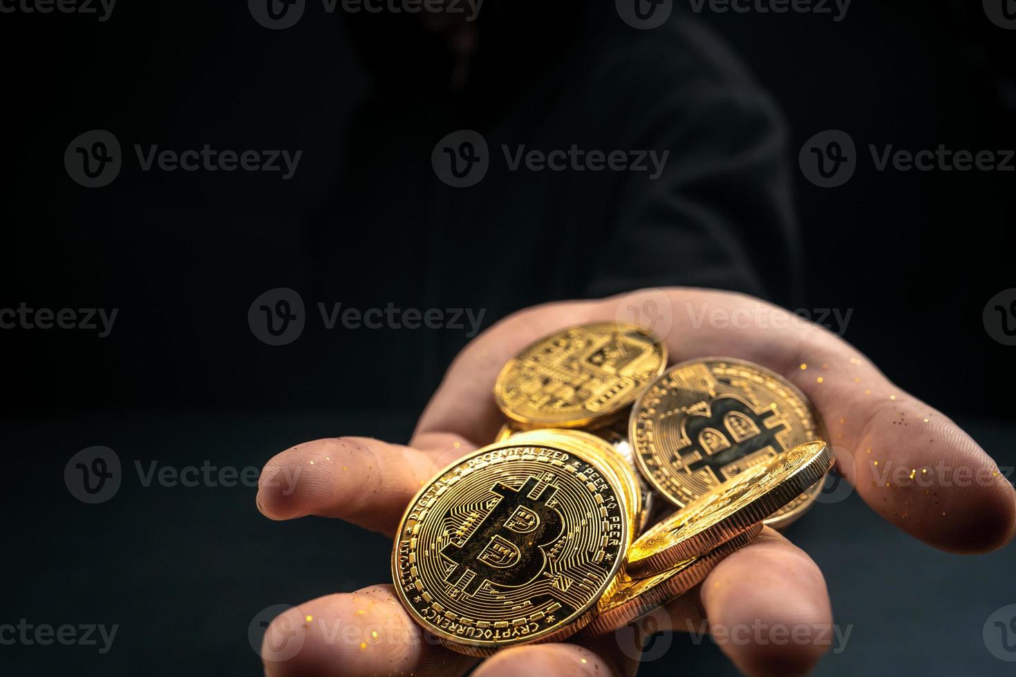 un bitcoin dorado en la mano de un hombre misterioso. foto