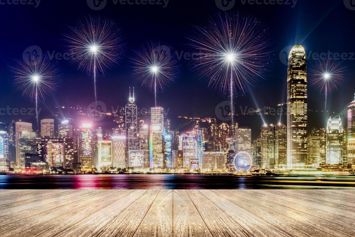 Piso de tablones de madera vacíos con fuegos artificiales sobre el paisaje urbano en el fondo de la noche foto