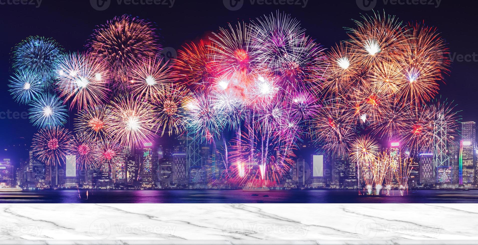 Happy new year fireworks over cityscape at night with empty white marlbe table photo