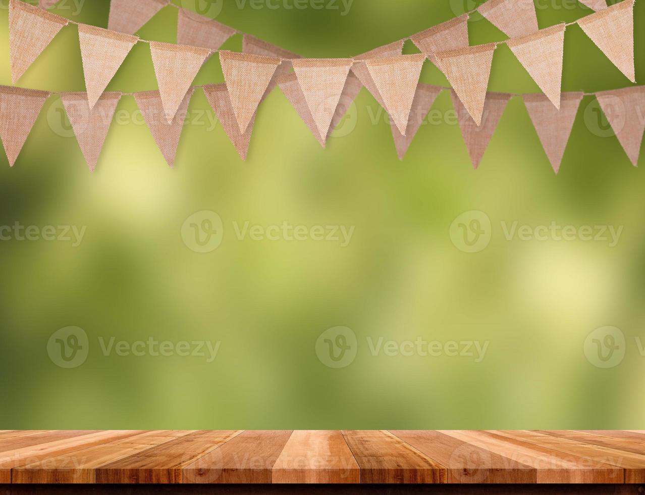Craft brown flag banner hang over wood table with blur green tree bokeh background. photo