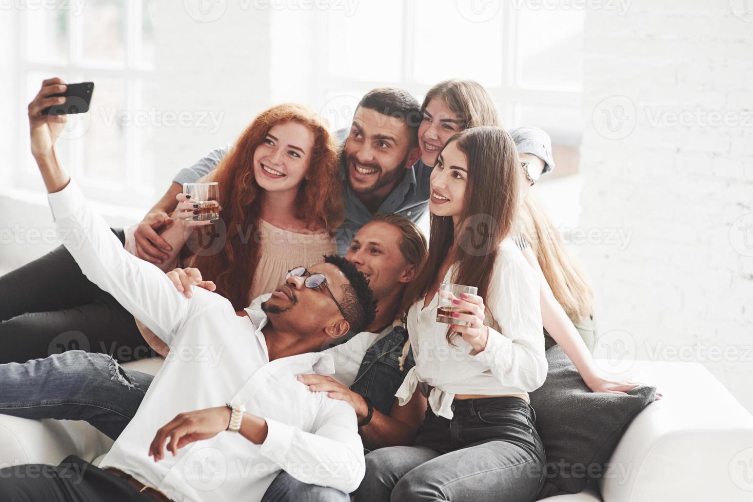 A little alcohol will not be superfluous. Group of multiracial teammates having good time on their break and taking some photos