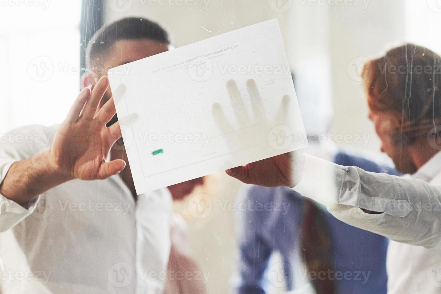 personas que trabajan en la oficina y discuten algunos detalles comerciales utilizando información en papel foto