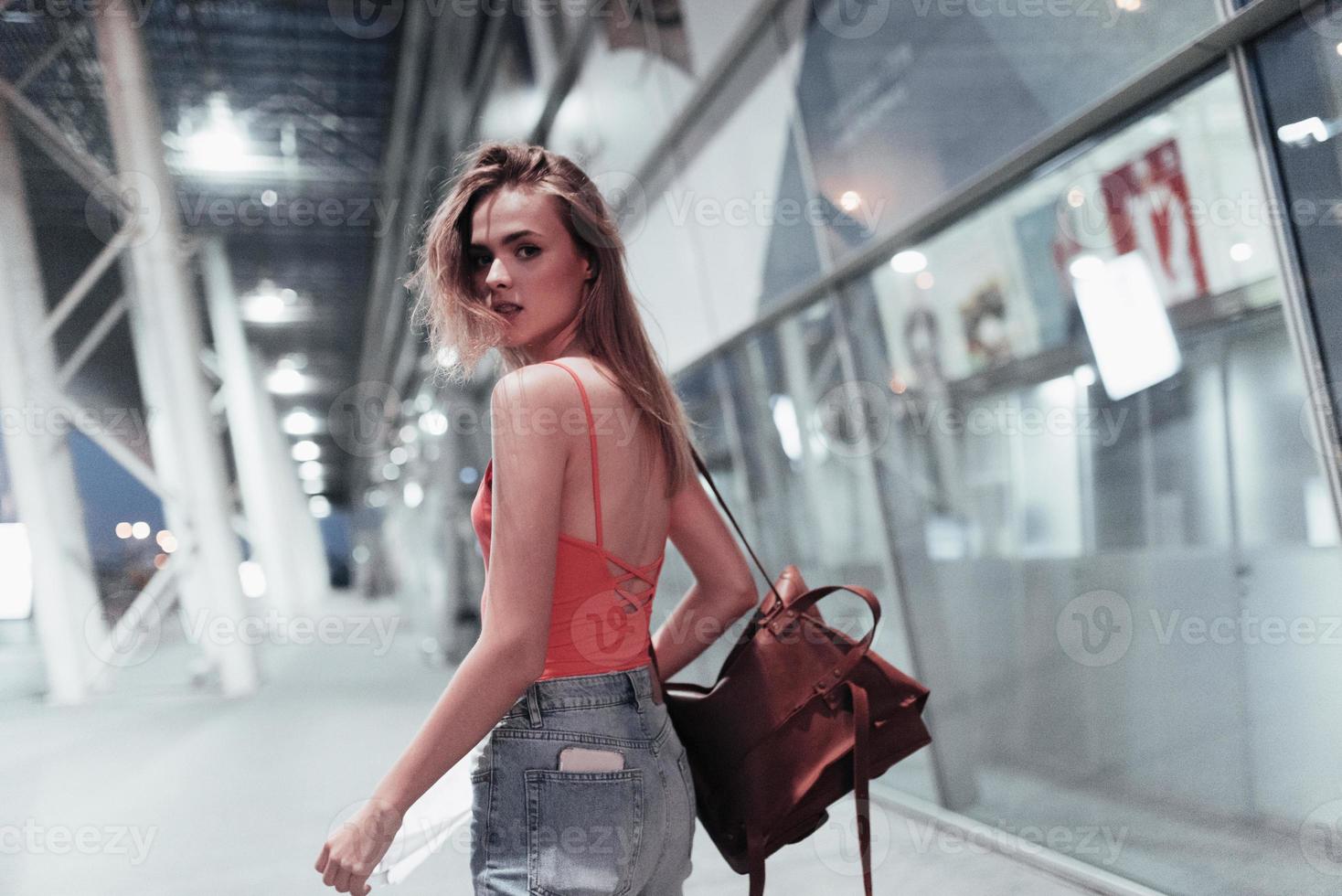 mira a la cámara. hermosa chica caminando cerca del edificio y darse la vuelta. foto en movimiento