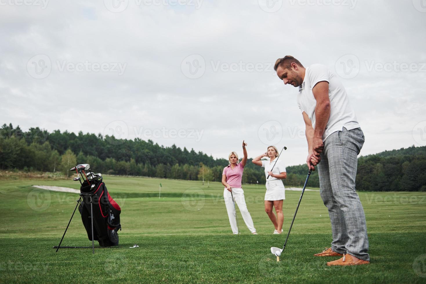 grupo de elegantes amigos en el campo de golf aprende a jugar un nuevo juego foto