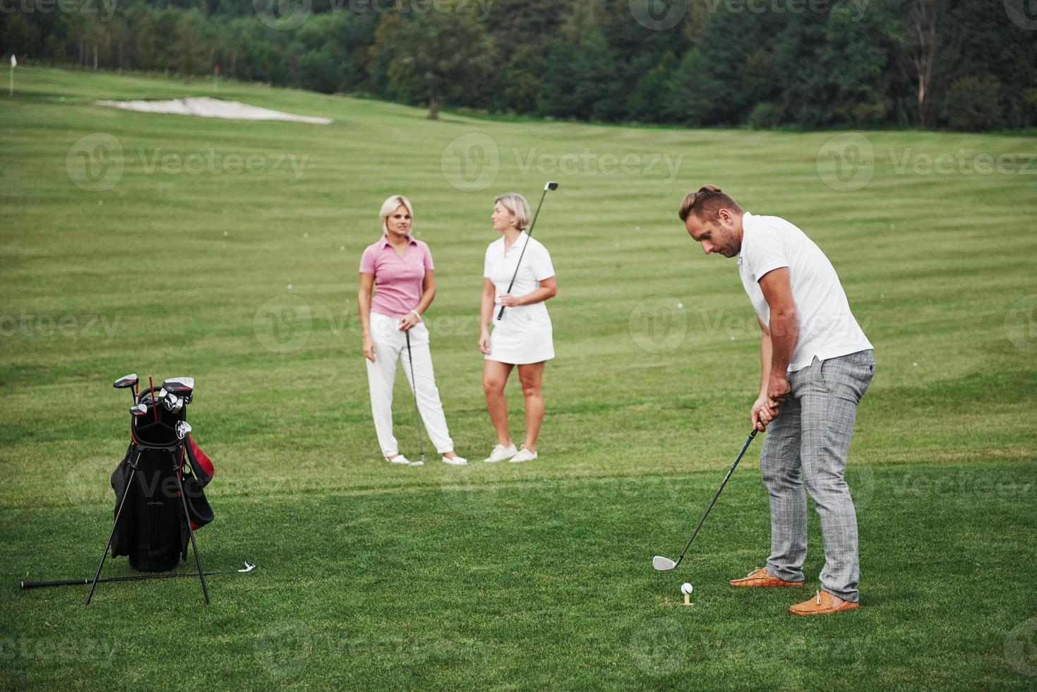 Group of stylish friends on the golf course learn to play a new game photo