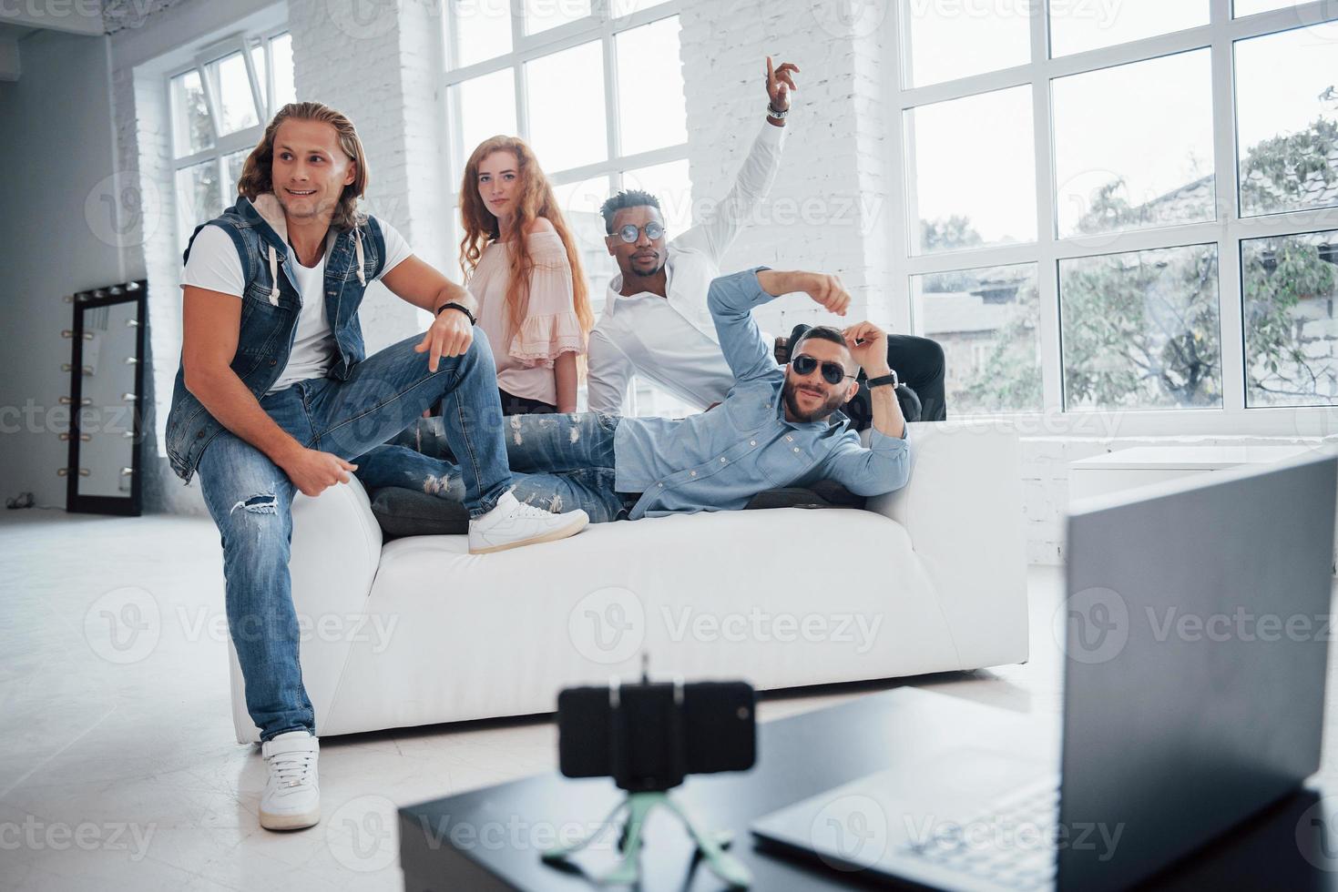 mirando de lado. los amigos han puesto el teléfono inteligente con temporizador automático en la mesa frente a ellos foto