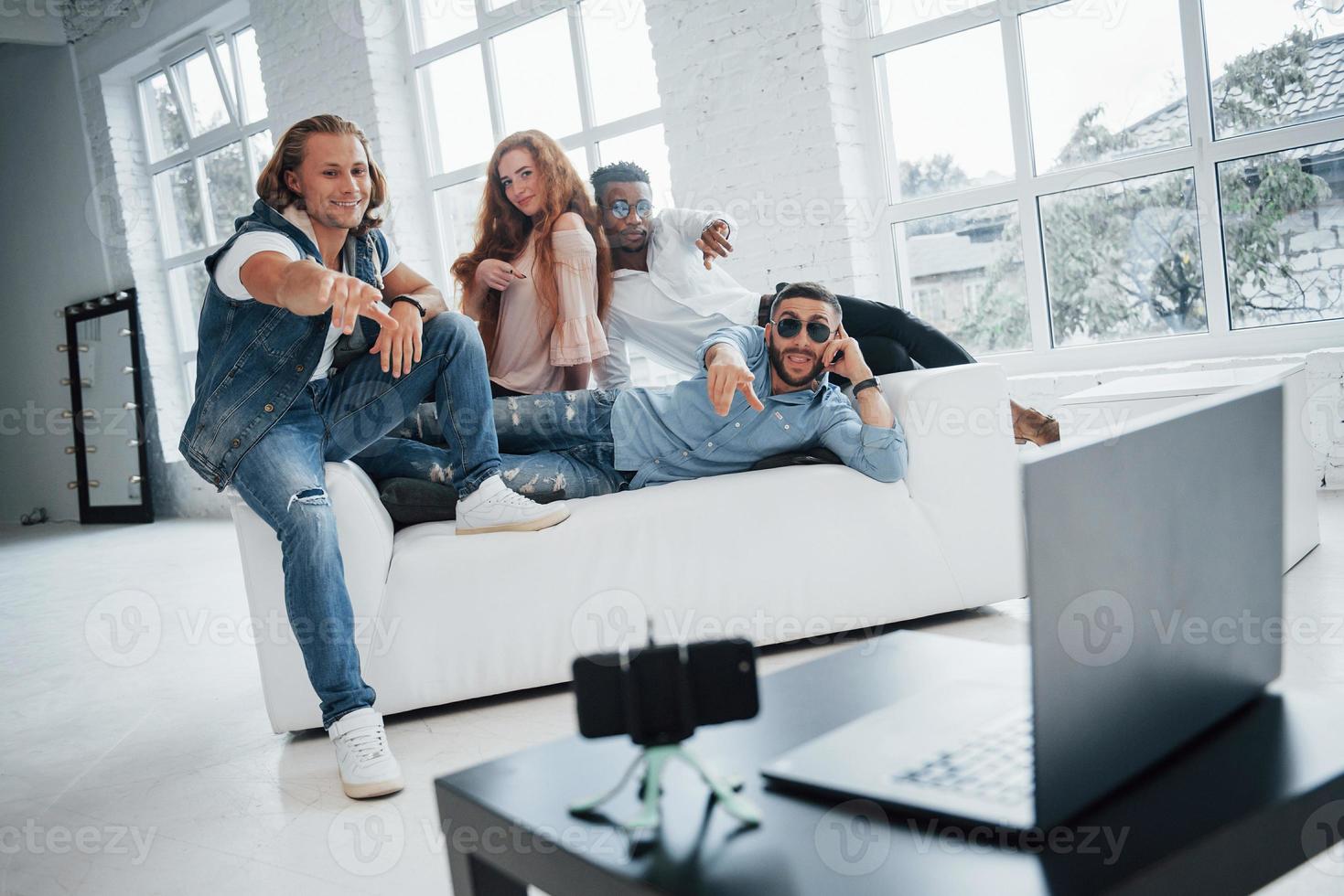 esperando la captura. los amigos han puesto el teléfono inteligente con temporizador automático en la mesa frente a ellos foto