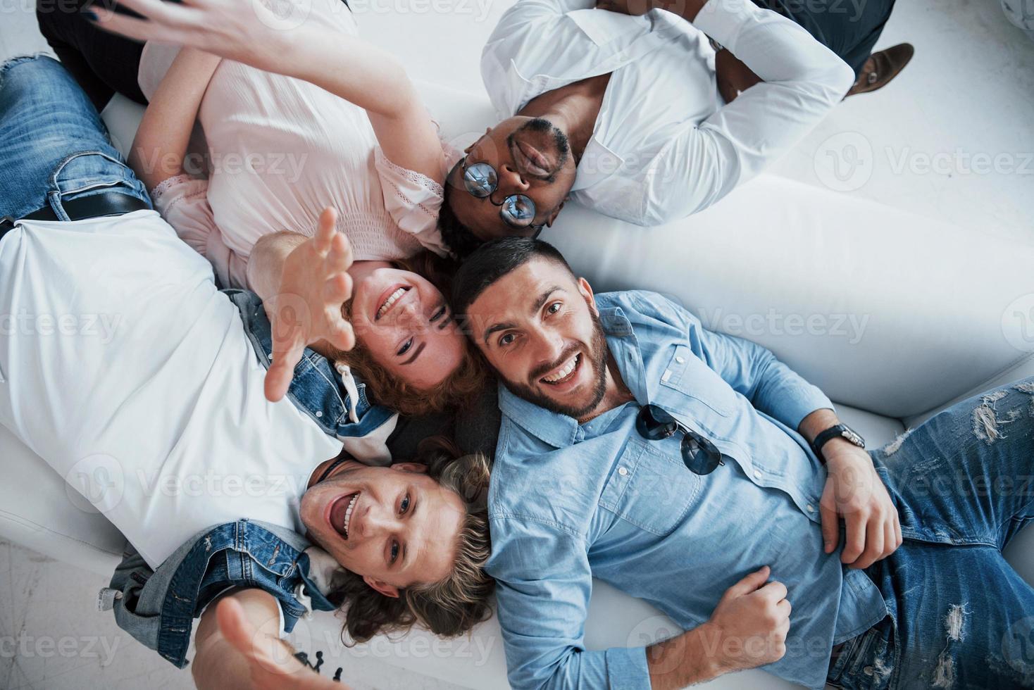 de cerca, vista de remolque. jóvenes acostados y sonriendo a la cámara. foto