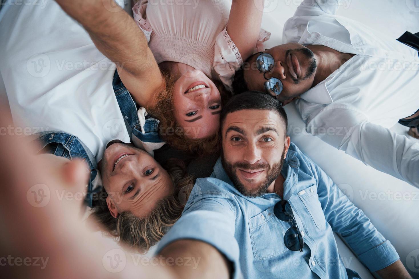 jóvenes que se acuestan y se toman una selfie. foto