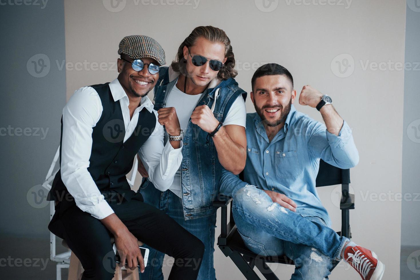 Unity and fists. Photo of smiling mixed race friends have photoshoot in the studio