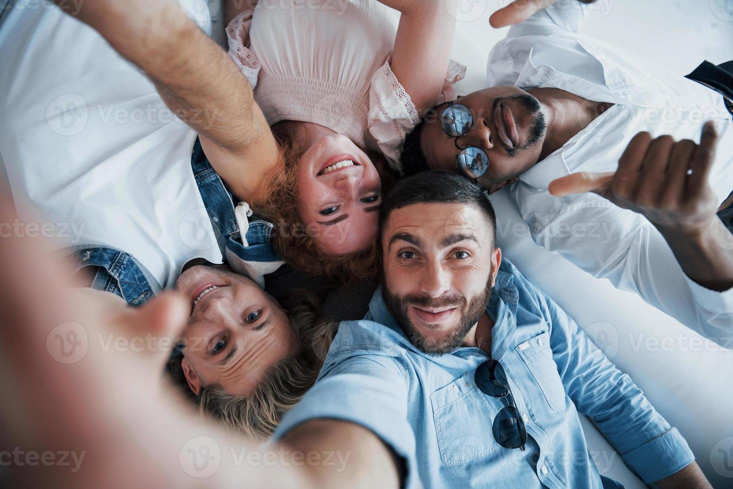 Afro american guy show thumb. Young people laying down and take a selfie photo