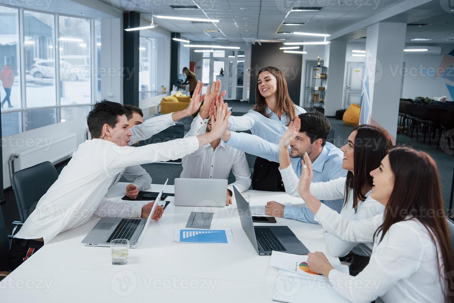 Cheerful business people. Job is done. Group of office workers happy to hit their own records and being successful photo