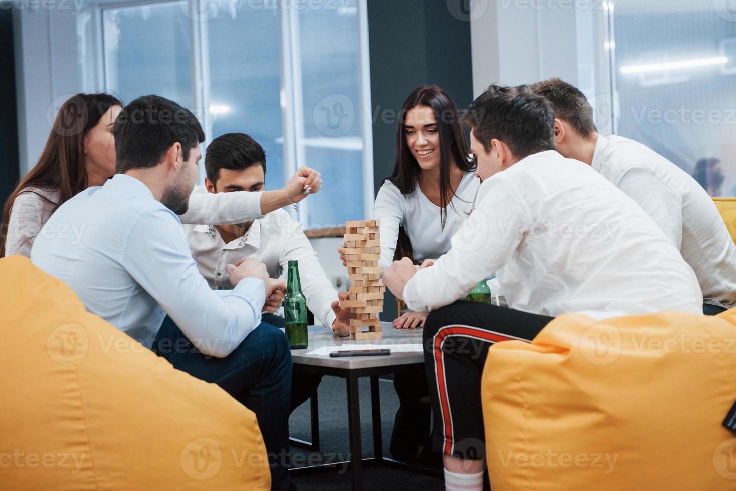 agradable velada en buena compañía. celebrando un trato exitoso. jóvenes trabajadores de oficina sentados cerca de la mesa con alcohol foto