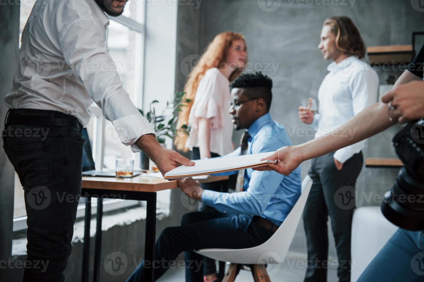 Having conversation. People in office sharing their work result to potential partner photo