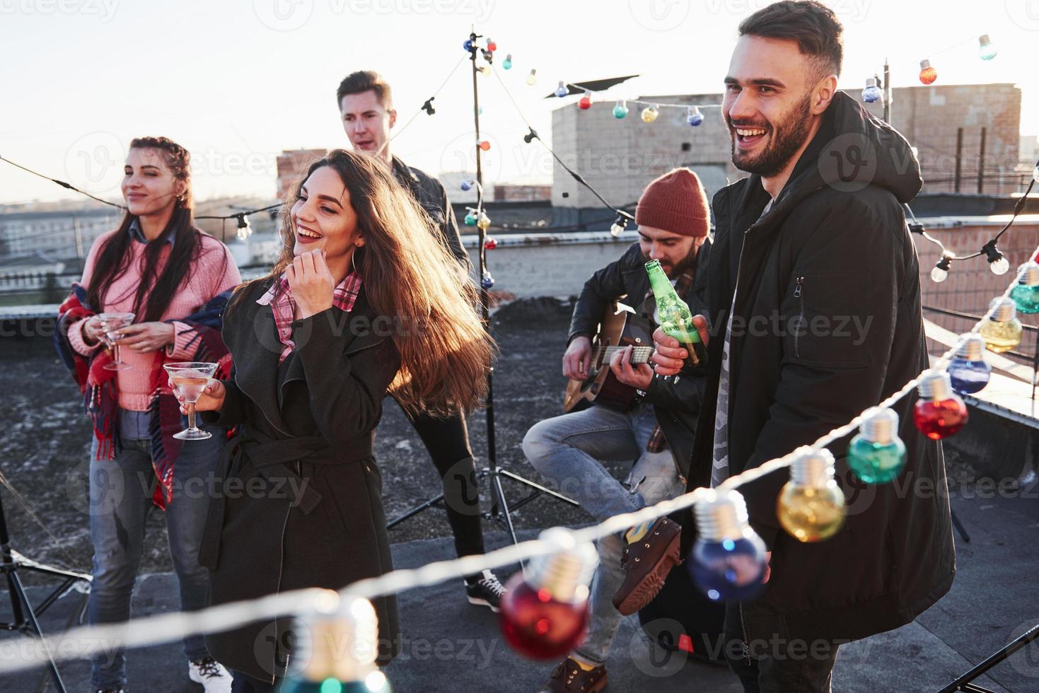 concepción del partido. bombillas por todo el lugar en la azotea donde un joven grupo de amigos ha decidido pasar su fin de semana con guitarra y alcohol foto