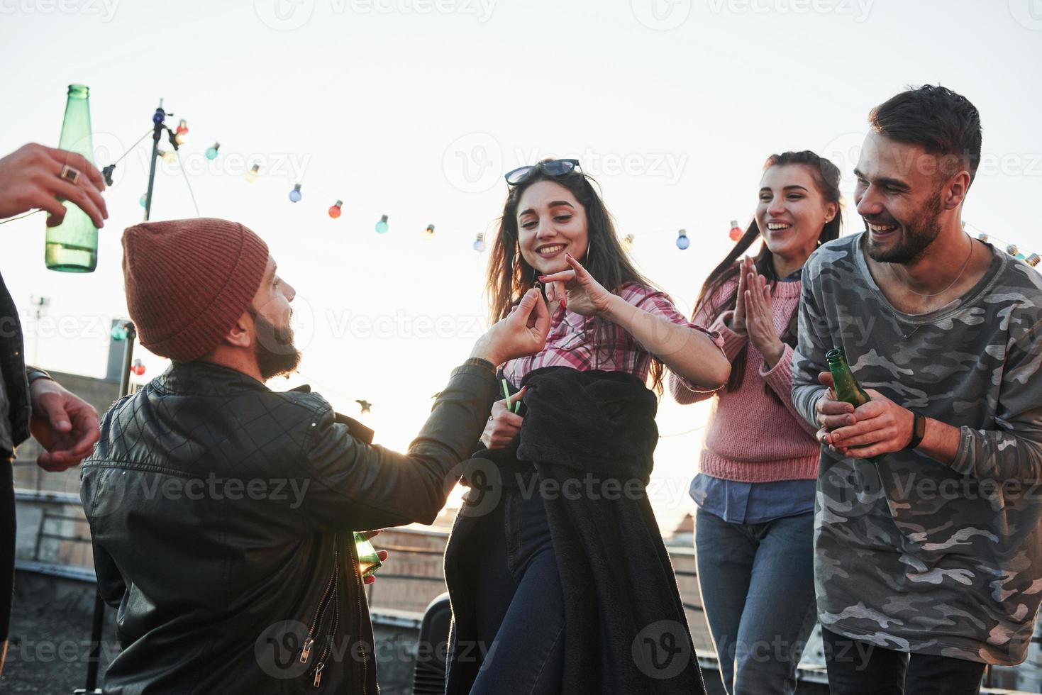 Be gentle with the ring. Declaration of love on the rooftop with company of friends photo