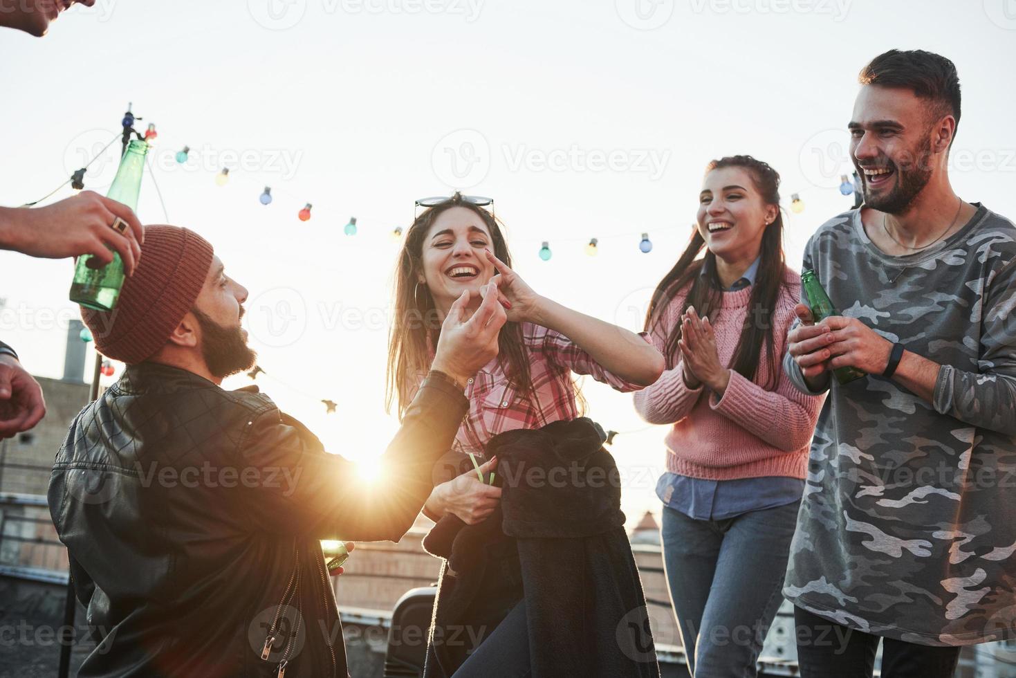 Wrong finger. Girl fooled the guy. Declaration of love on the rooftop with company of friends photo