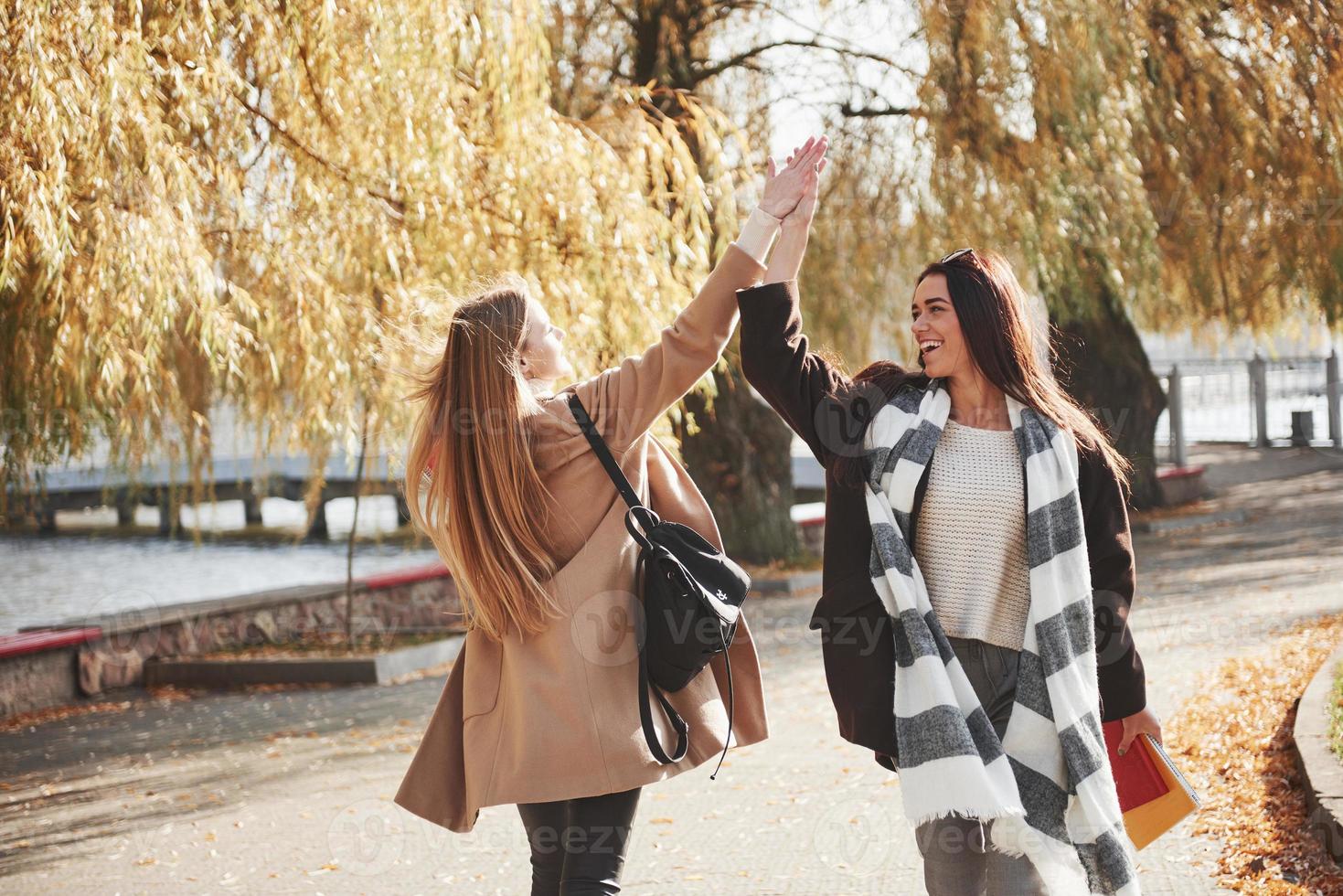 High five. Two young friends are glad to meet each other at park after the studying photo