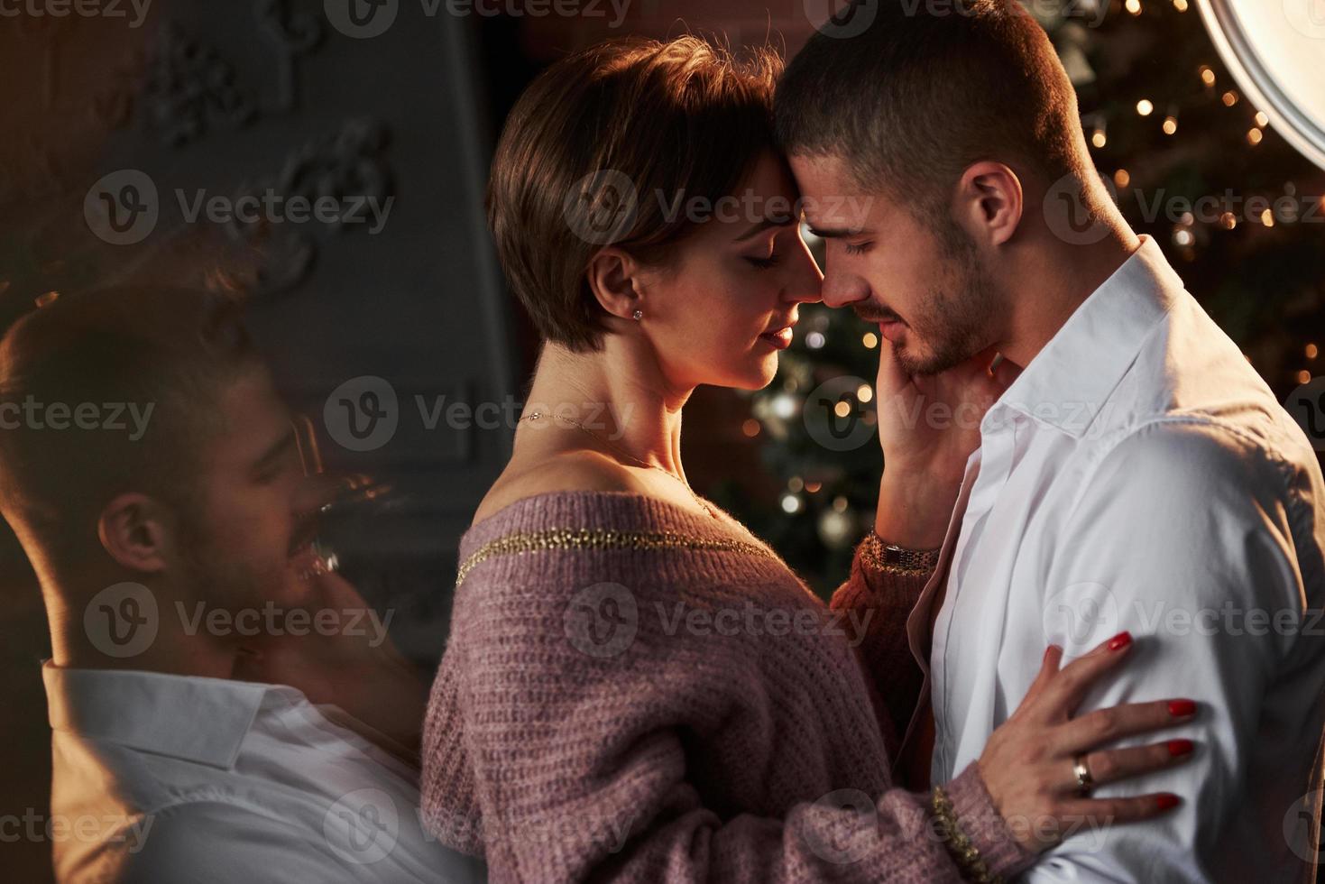 Side view. Closeness of the guy and girl in luxury wear that dancing and flirting. Gorgeous reflection from the side photo
