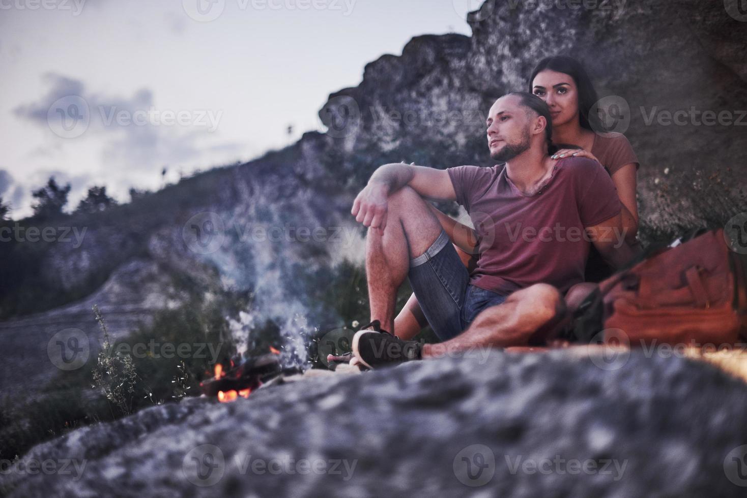 Two loved people have camping in the evening at the end of theirs walk through woods and mountains photo