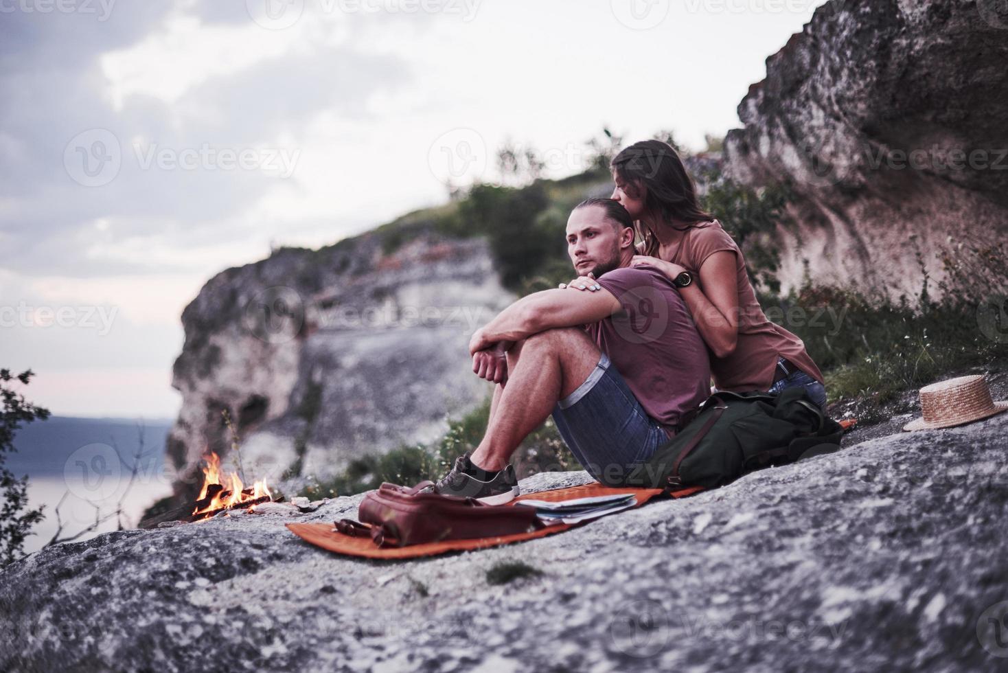 Thoughtful look. Two loved people have camping in the evening at the end of theirs walk through woods and mountains photo