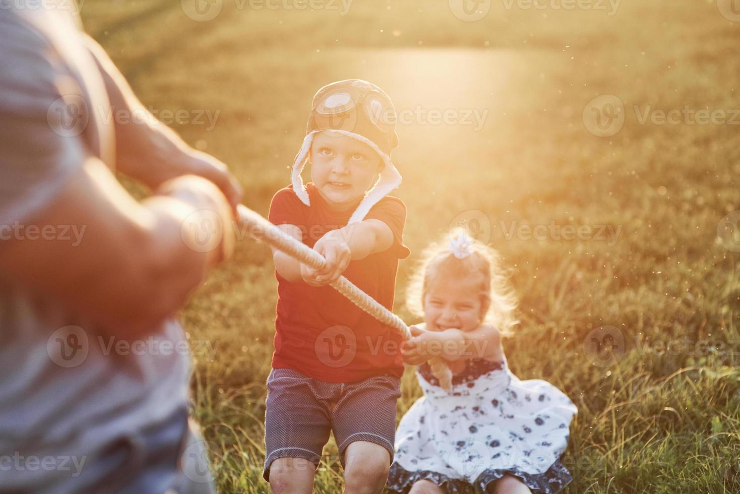 haciendo mi mejor esfuerzo. esto es tira y afloja con papá en la hermosa hierba de un día cálido y soleado foto