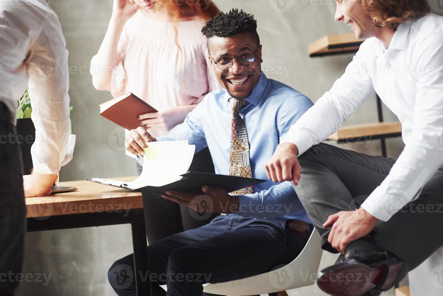 sonriendo mientras hace el trabajo. trabajadores de oficina que tienen conversación durante su trabajo foto