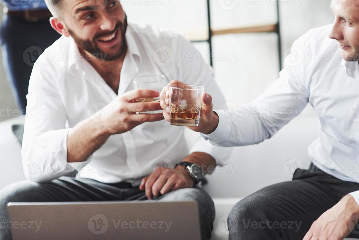 Can't believe this worked. Two colleagues celebrating good deal in their business by drinking alcohol photo