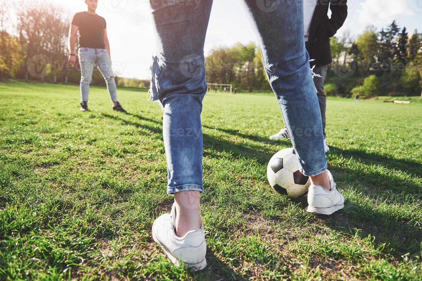 A group of friends in casual outfit play soccer in the open air. People have fun and have fun. Active rest and scenic sunset photo