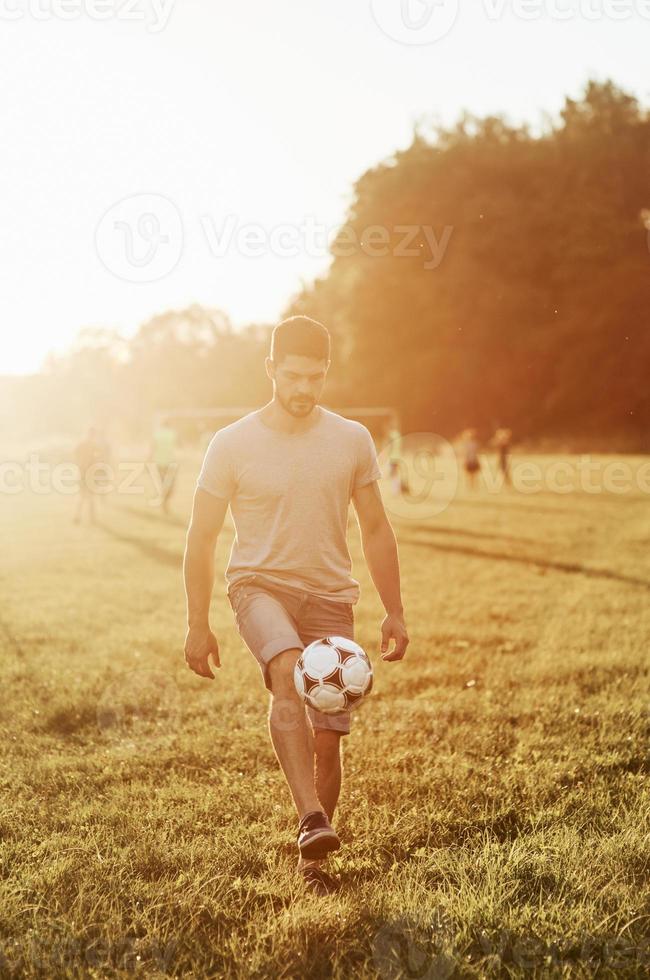 hombre patea el balón de fútbol. entrenar habilidades antes de que pueda mostrarle a su propia hija cómo hacerlo foto