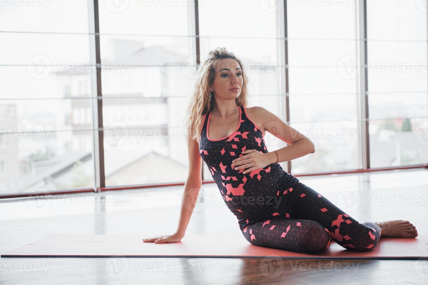 concepto de embarazo de yoga y fitness. retrato de un modelo joven de una mujer embarazada que se desarrolla en interiores. foto
