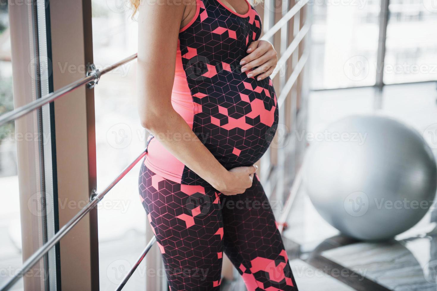 el concepto de deporte y fitness de una mujer embarazada y lleva un estilo de vida saludable en el gimnasio foto