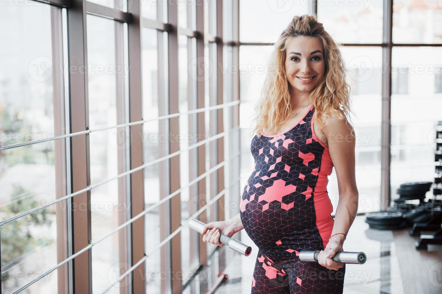 Conception of pregnancy, sports, fitness and healthy lifestyle in the gym. photo