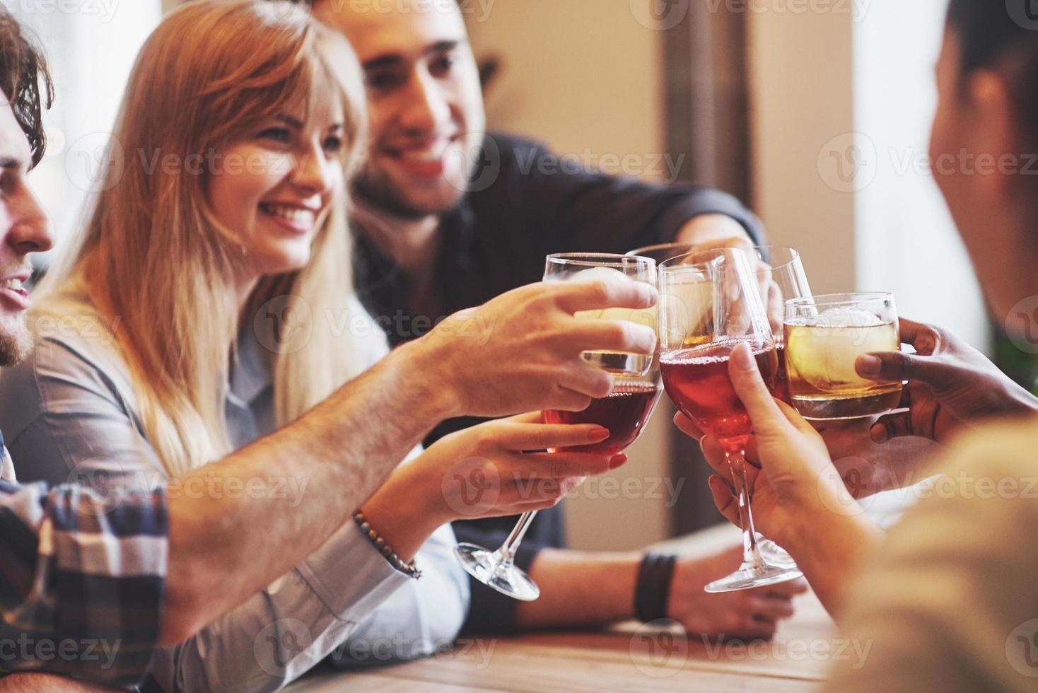 Manos de personas con vasos de whisky o vino, celebrando y brindando en honor a la boda u otra celebración. foto