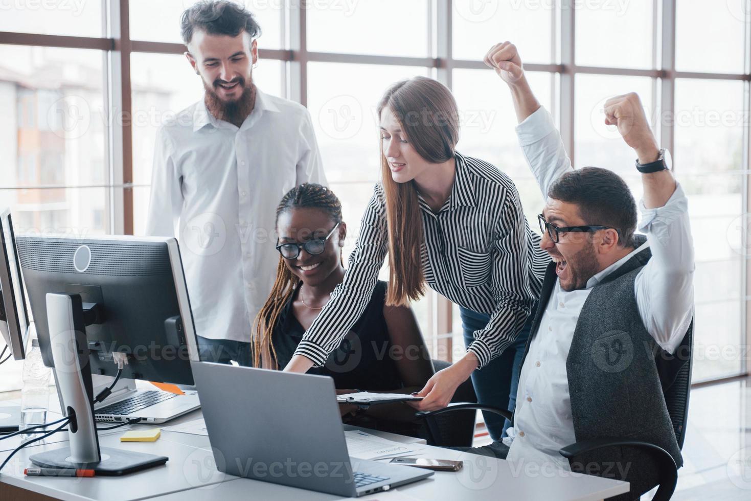 jóvenes empleados sentados en la oficina en la mesa y usando una computadora portátil, un concepto de reunión de intercambio de ideas de trabajo en equipo. foto