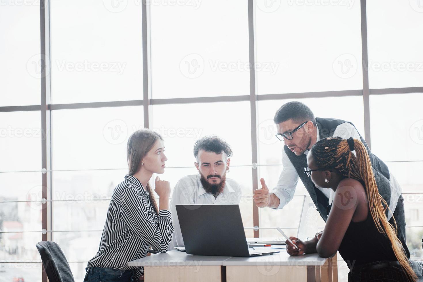 Un grupo de personas ocupadas multinacionales que trabajan en la oficina. foto