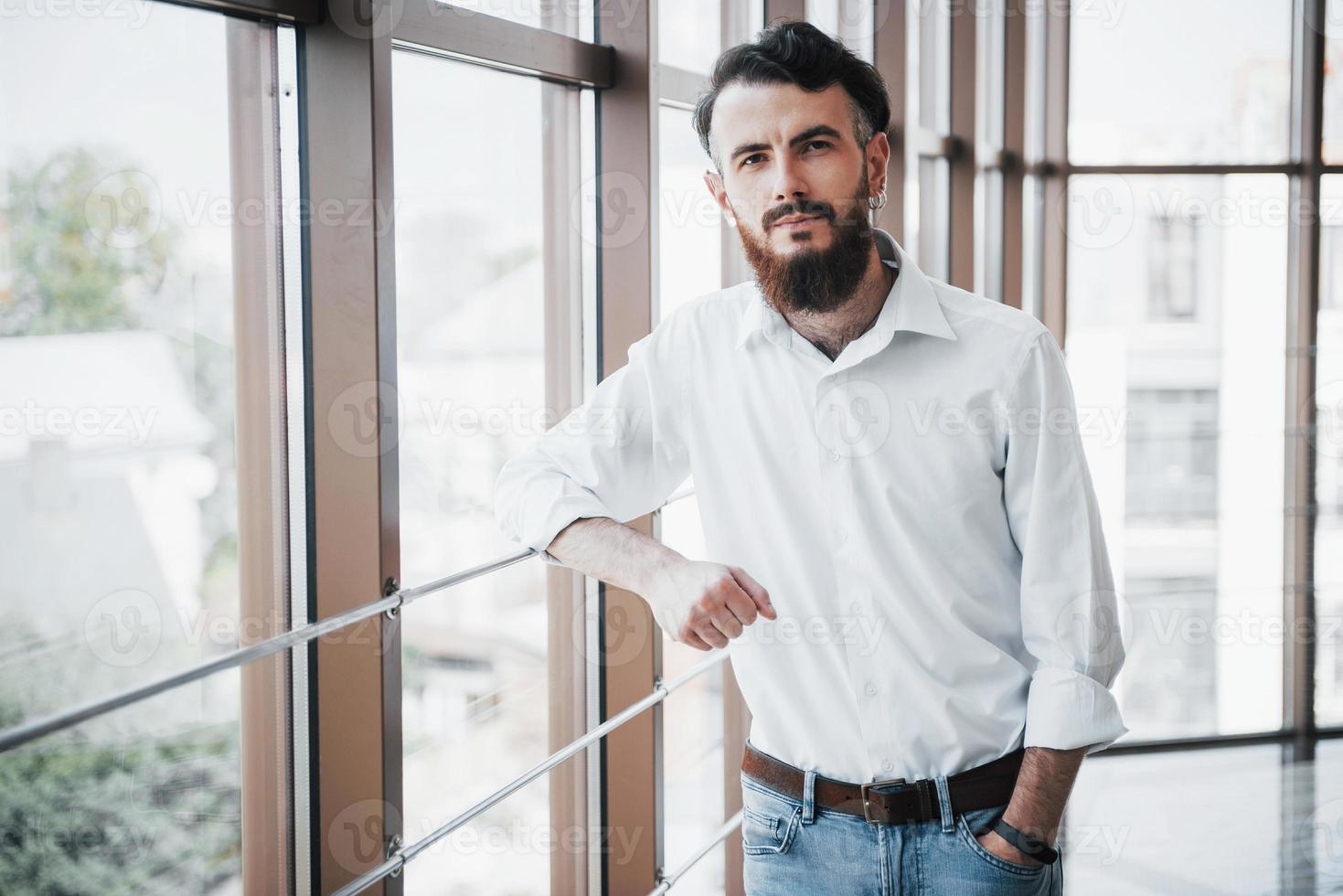 A seductive man in a white shirt looking at the camera. photo