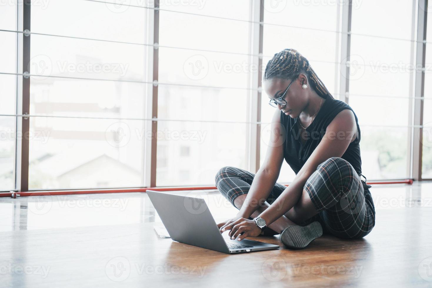 una joven mujer afroamericana está feliz con una computadora portátil. foto