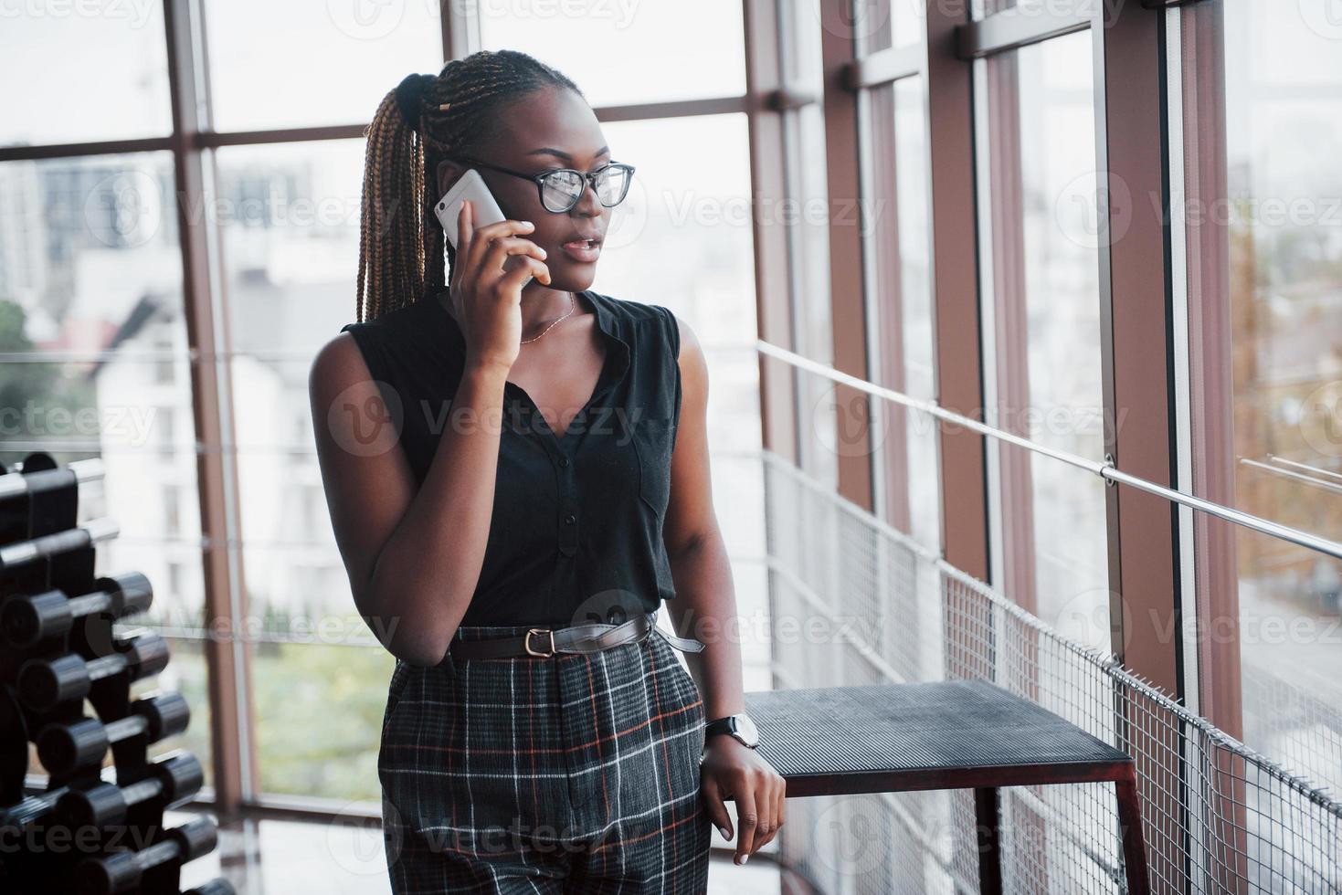 una mujer de negocios estadounidense habla por su teléfono celular en la oficina. foto