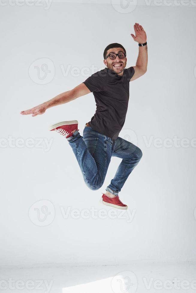 Image of cheerful young man casual dressed jumping over white background make different gesture photo