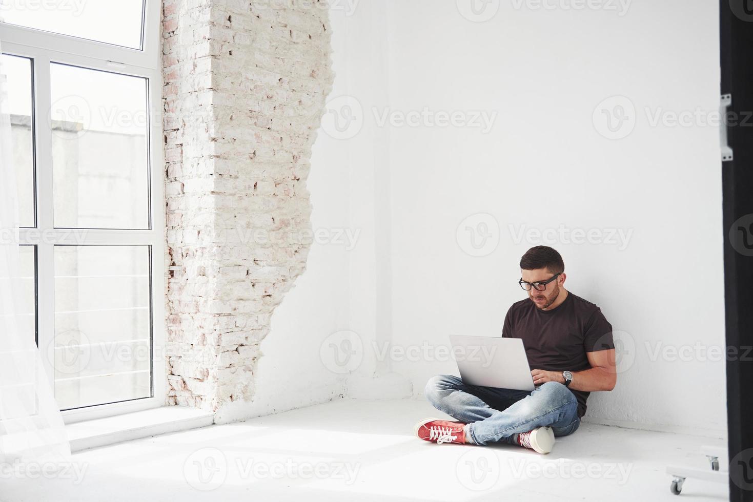 Handsome young man with laptop and check his timetable on white background photo