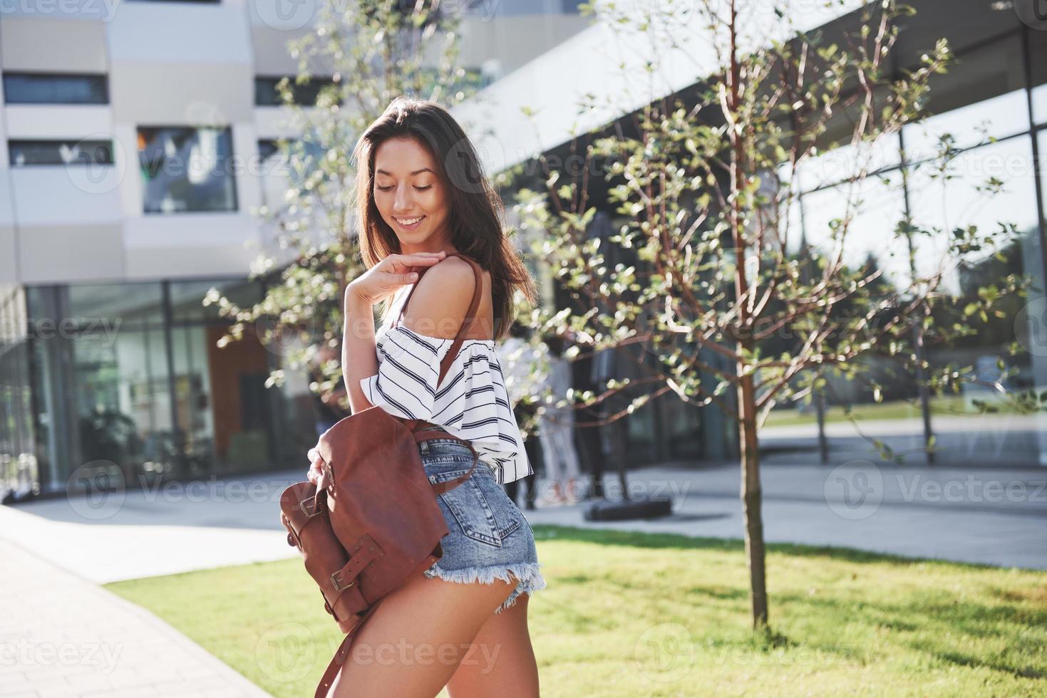 Beautiful, happy young student girl with backpack near the campus of university. Education and leisure concept photo