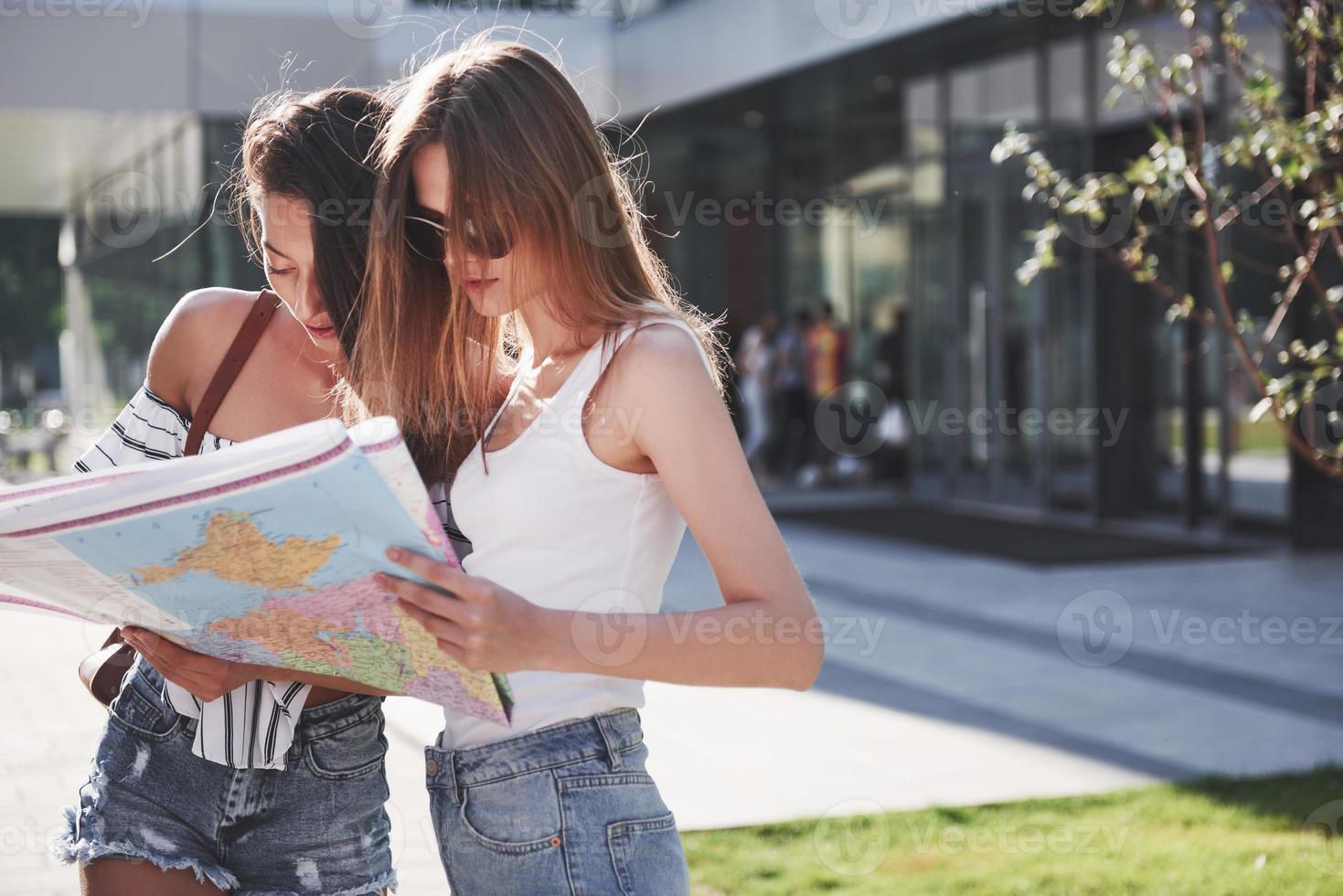 Dos turista con mapa visitando una nueva ciudad y está buscando un camino al hotel. foto