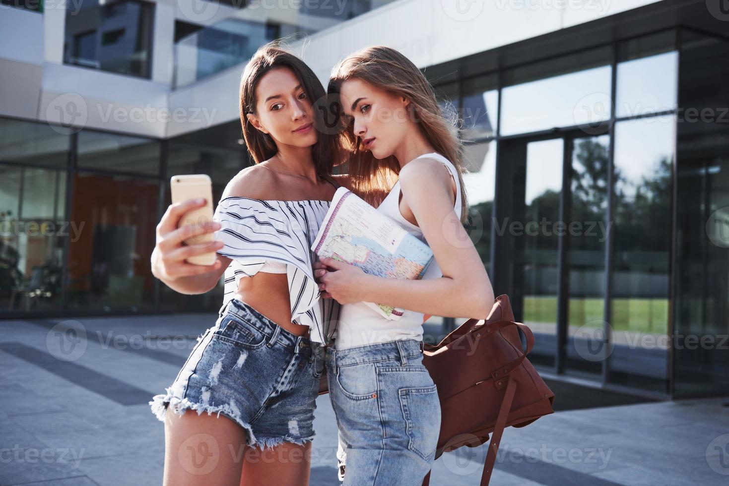 dos hermosa chica joven estudiante feliz con mochila cerca del campus de la universidad y hacer una foto selfie. concepto de educación y ocio